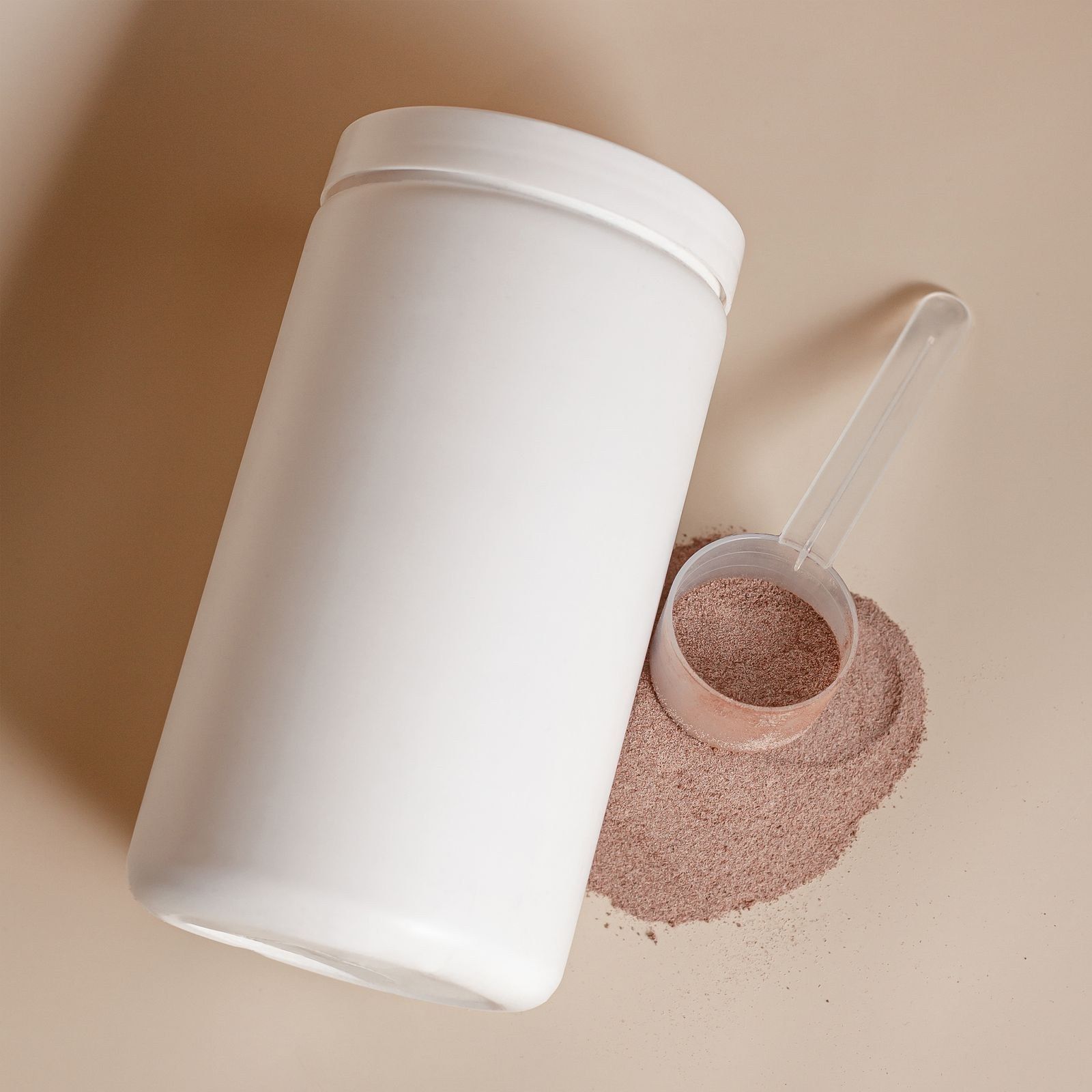 Pote de suplemento e medidor com whey sobre fundo bege